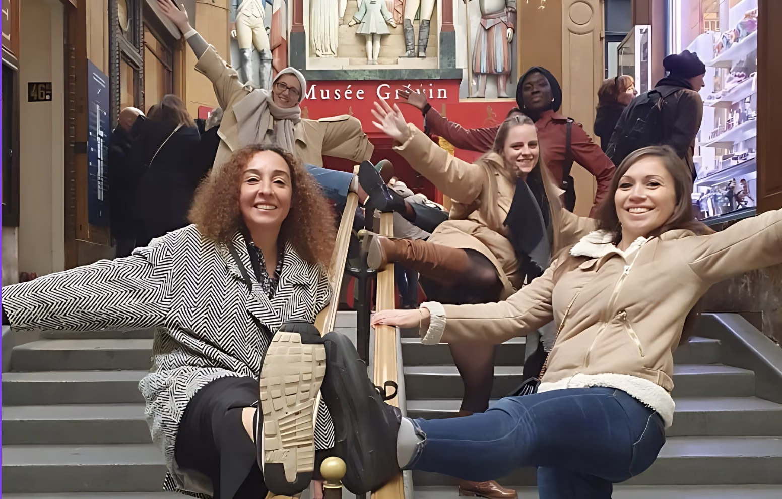 Groupe de collaborateurs explorant les passages couverts de Paris lors d'un team building jeu de piste, ambiance chaleureuse sous les verrières du XIXe siècle