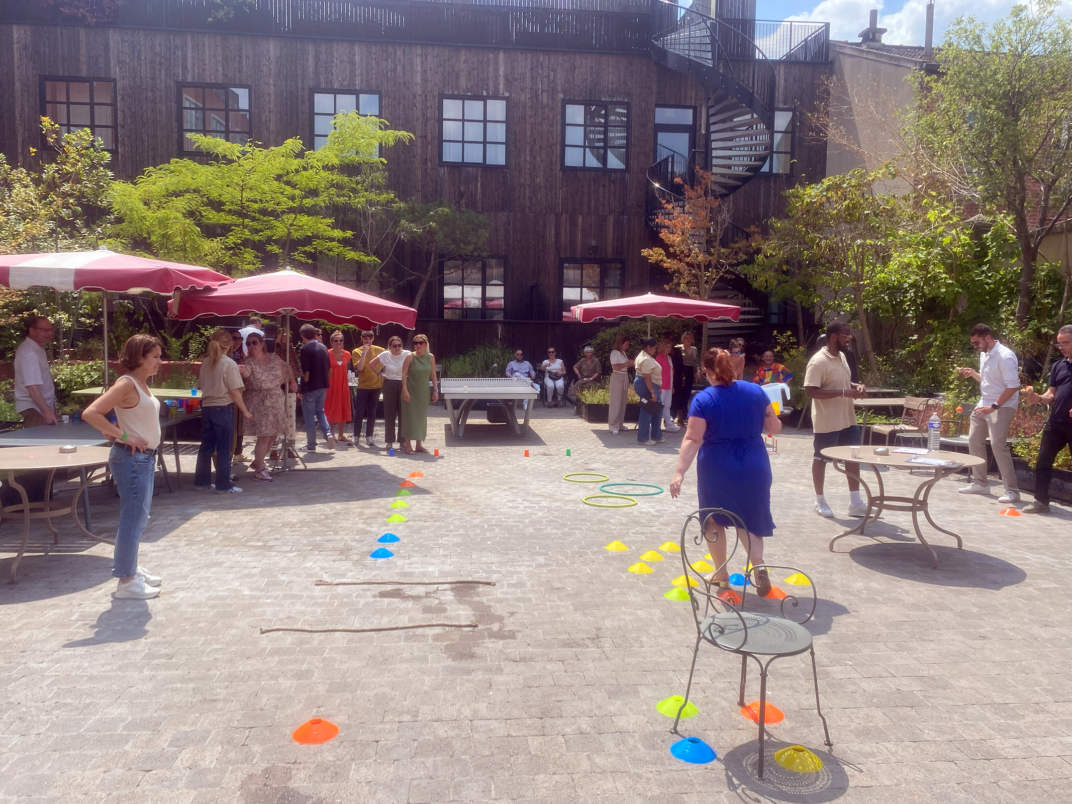 Animateurs professionnels encadrant une épreuve collective en extérieur lors d'un team building d'entreprise, groupe d'une quarantaine de participants en plein air
