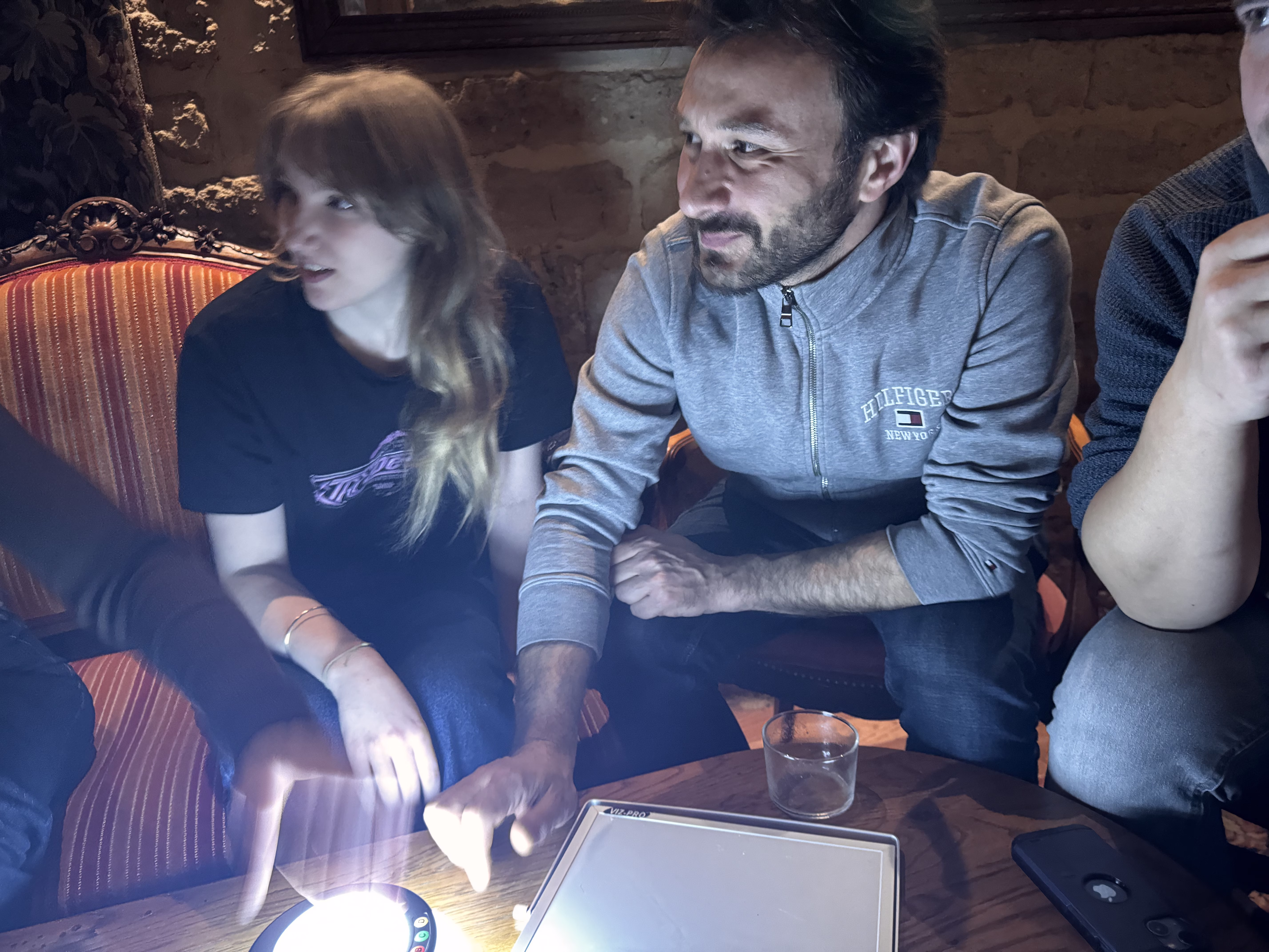 Groupe de collaborateurs en plein Blind Test en entreprise, buzzers sur la table, ambiance animée et festive lors d'un séminaire B2B