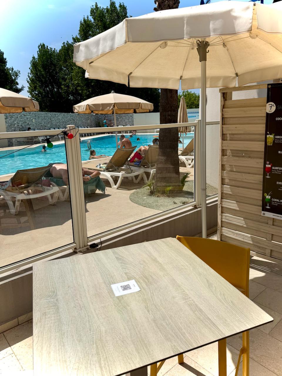 QR code menu multilingue affiché sur table à la terrasse du Bonap, solution digitale pour consulter la carte