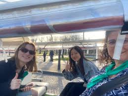 Groupe de collaborateurs à bord d'un tuk-tuk dans les rues de Paris lors d'un team building, ambiance ludique et découverte urbaine