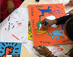 Participants en entreprise travaillant ensemble sur une grande fresque collaborative colorée inspirée de Keith Haring, lors d'un atelier team building à Lyon